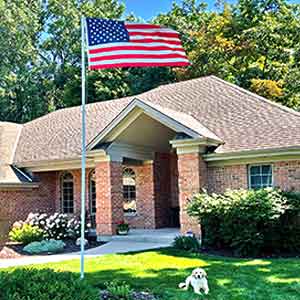 American flag flying on a pole in front of a home
