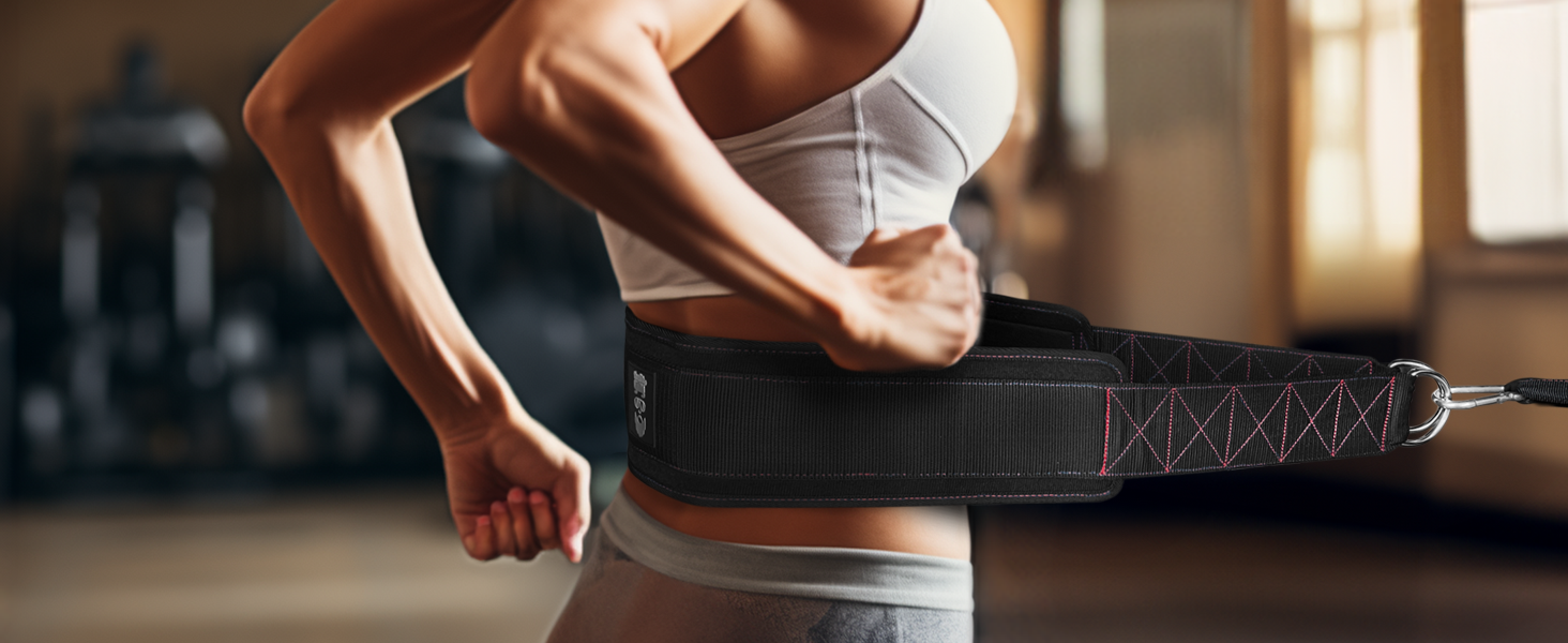 Woman sprinting with sled pulling belt, showing secure fit and side D-ring attachment in gym setting