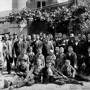a group of men pose for a picture in front of a building.