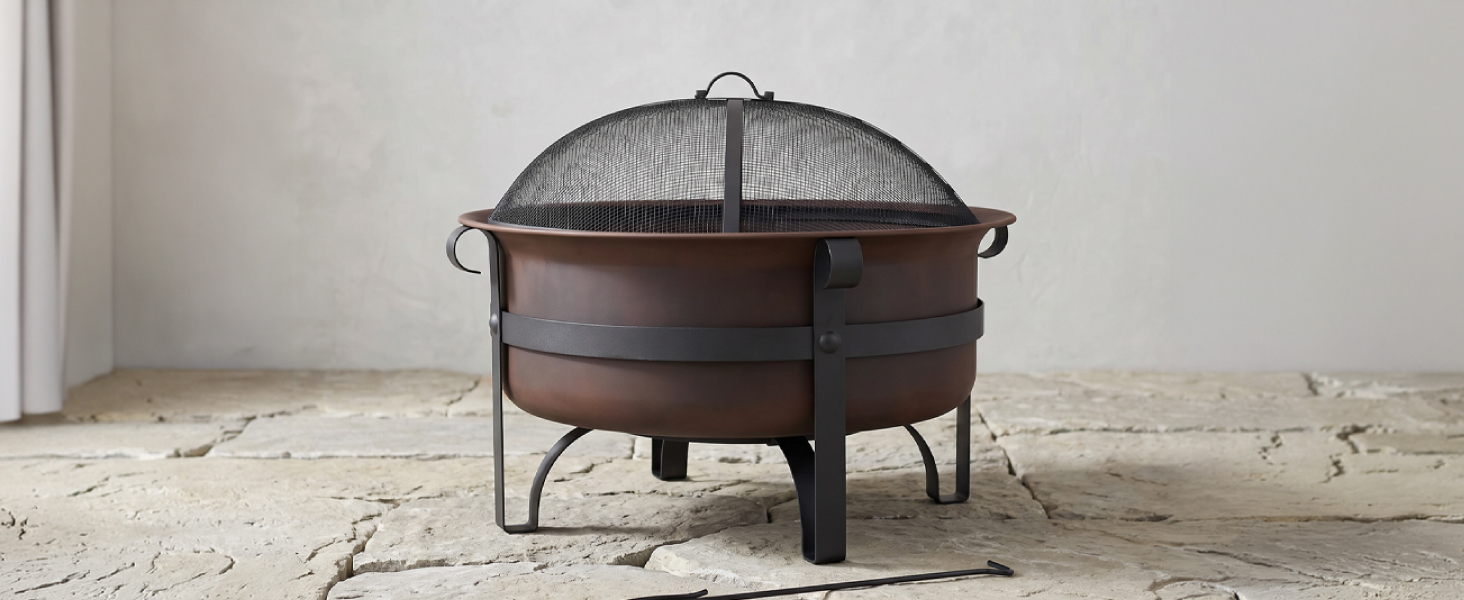 29-inch cauldron fire pit with mesh spark screen and poker on stone floor with grey background