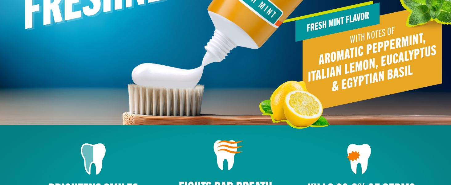 Fluoride toothpaste gel being squeezed onto a toothbrush with lemon and basil denoting freshness