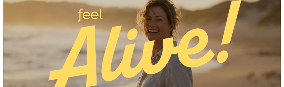 Woman standing on a beach at sunset smiling at the camera