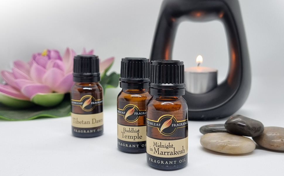 Three 10ml bottles of fragrant oil with a black ceramic oil burner in the background.