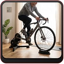 Rider doing a controlled indoor session on a trainer with an indoor cycling front wheel block suppo.