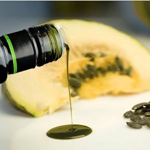 pouring podor styrian pumpkin seed oil on a plate