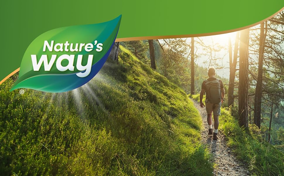 Man walking on green mountain trail in the forest.