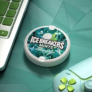 Ice Breakers wintergren flavored mints on a desk with a laptop and game controller