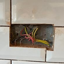 a broken electrical box in a bathroom
