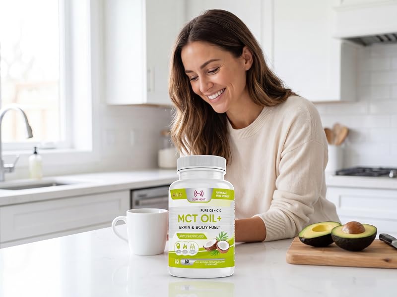 Smiling woman in a bright kitchen looking at Slim Heat MCT Oil softgels by a coffee mug