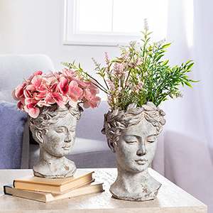 goddess planters on table with floral arrangements