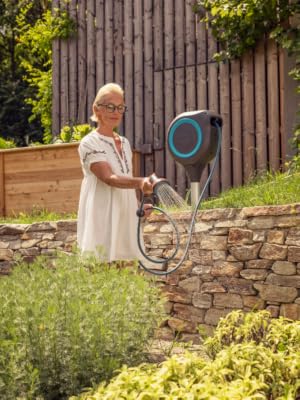 Woman watering plants with a GARDENA hose reel.