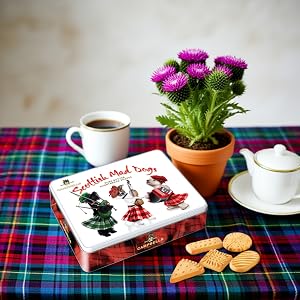 dogs in kilts shortbread cookies tin with tea set and tartan cloth on table