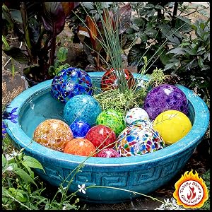 Colorful Pond floats, garden gazing balls, patio and outdoor decor floating in a teal bowl.