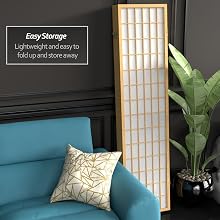 A multipanel shoji screen has been folded together into a small space and stored beside a couch