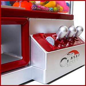 inserting a token into the mini claw machine to activate the toy