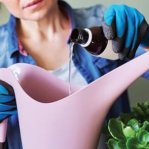 Synthetic fertilizer being added to a watering can.