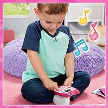 Kid pushes buttons on A-Meow-Zing Phone. Notes illustrate music.