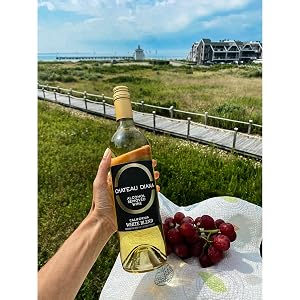 A person's hand holding a bottle of Chateau Diana Alcohol-Removed California White Wine Blend.