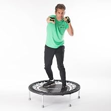 Man on mini fitness trampoline boxing to lose weight and create lymphatic flush
