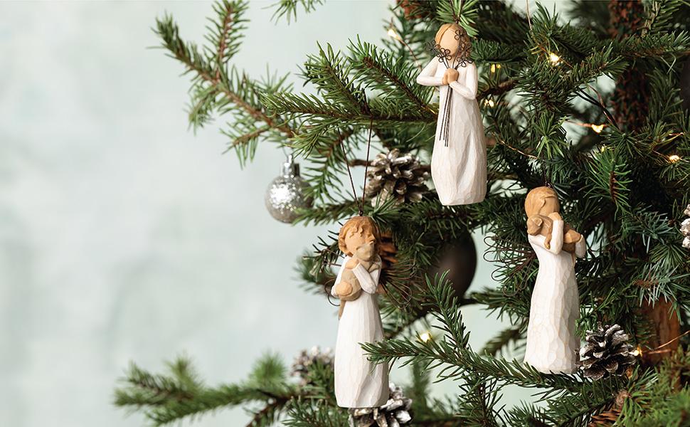 Various angel figures expressing joy and friendship hanging on a decorated Christmas tree