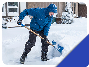 someone in a blue coat shoveling snow