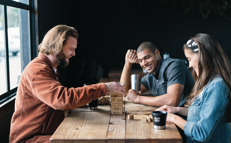 Friends and family playing a game with tumblers and one tumbler lid