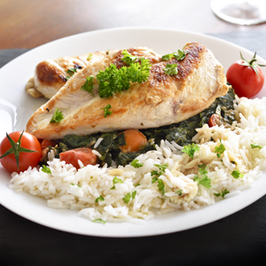 plate of chicken, rice, tomatoes, and spinich