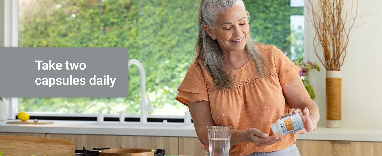 Woman taking two MacularProtect capsules daily with water for long-term macular health support.