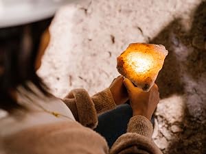 A miner illuminates a salt rock to show it&amp;#39;s pink color.