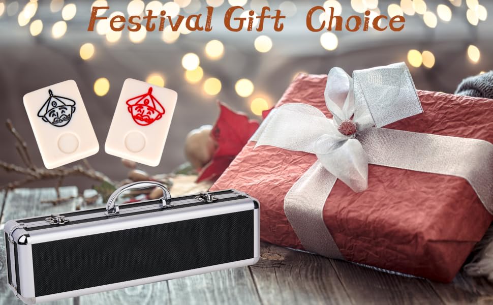 Festival gift display with red wrapped present, white bow, metallic briefcase, and two gift tags against blurred light background.