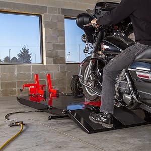 Man Rising Touring Onto Black Widow Motorcycle Lift Table in Garage Shop with Front Wheel Chock