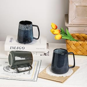 a set of three ceramic mugs with a flower vase