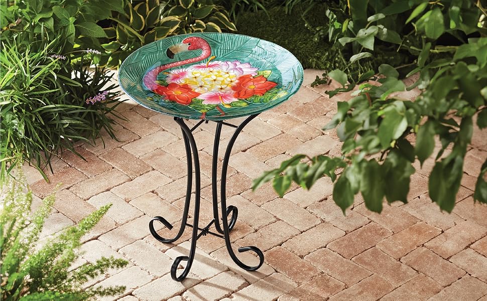 the flamingo birdbath is displayed in a lush patio garden