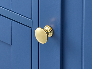 Close-up of brass or gold-toned door handles against vibrant blue door panels.