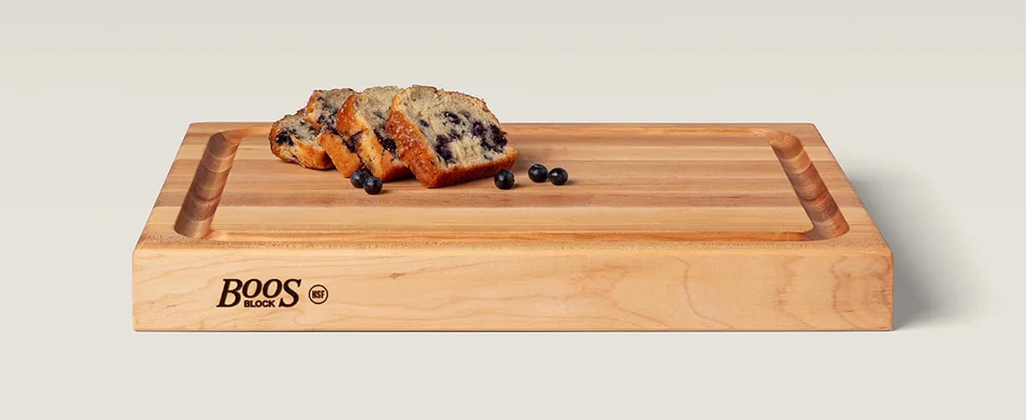 Rectangular wood cutting board with loaves on top, showcasing smooth finish and rich grain.