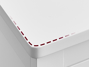Close-up of a white surface edge with a red dotted line, possibly indicating a cutting or folding guide.