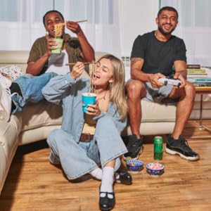 people at home enjoying ramen express, eating from the cup, playing video games