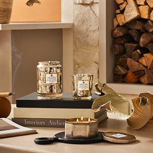 Blond Tabac large jar, classic candle and 3 wick tin near a stack of firewood.