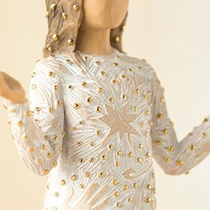 Close up detail of gold embellishments on figures dress.