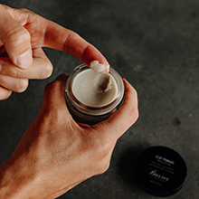 A person&amp;#39;s hand with a fingernail-sized scoop of Clay Pomade on their finger