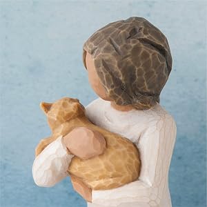 Close up detail of figure holding cat in arms.