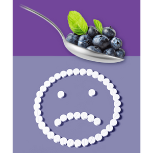 Spoon full of berries, pills arranged in a sad face