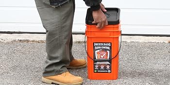 Quick Dam Bucket Kit with lid being taken off in front of garage door