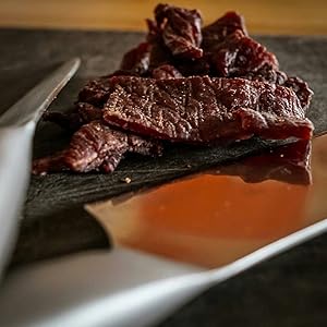 beef jerky sitting on a table, looking super delicious