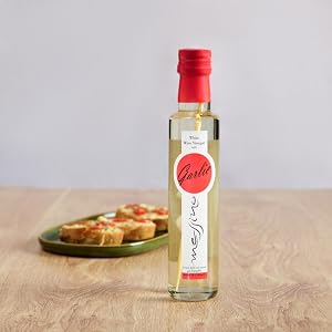 Messino White Wine Vinegar with Garlic bottle next to plate of bruschetta