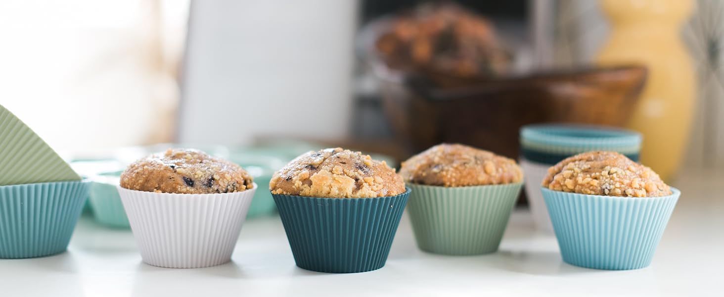 Free-standing silicone baking cups in white, navy, sage, and light blue with muffins in them