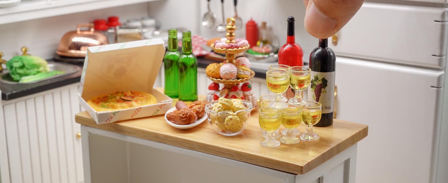 Kitchen counter with wooden tray holding miniature food items, bottles, and glasses. Hand reaching to interact with the small-scale display.