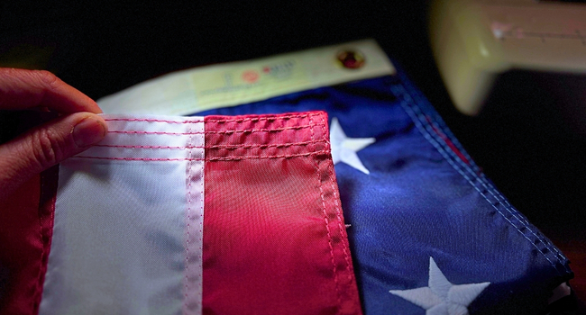 Quad-stitched hem on a nylon American flag showing reinforced fly end construction.