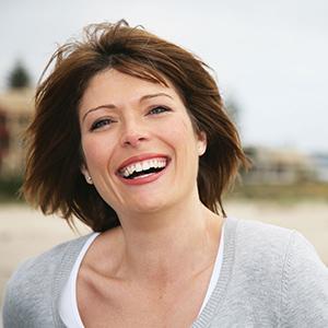 Woman smiling on a beach stroll