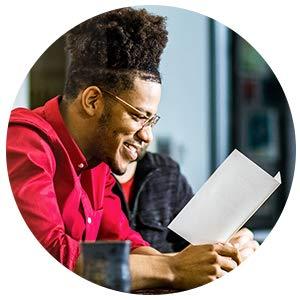 man smiling reading a card